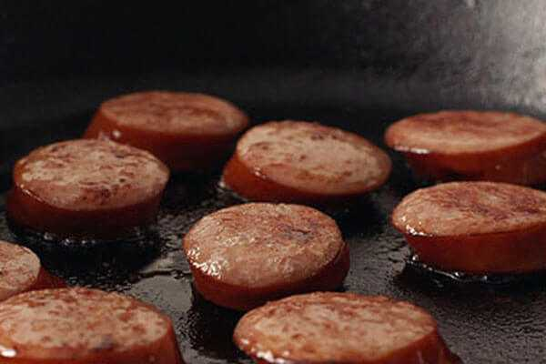 Sliced Sausage being cooked in a pan